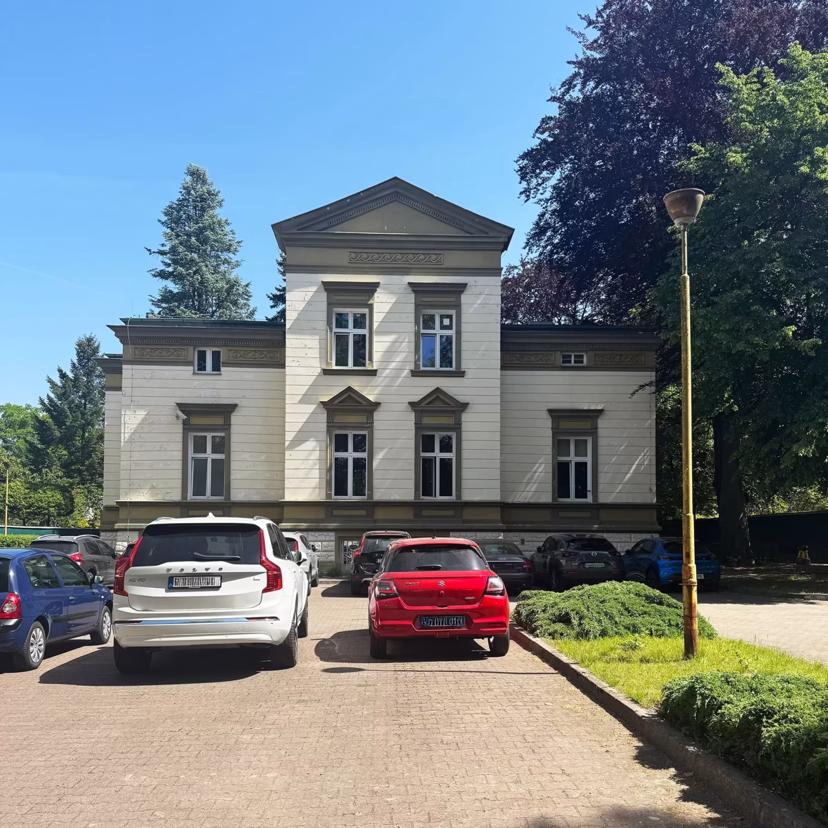 Parking wewnętrzny na terenie Prywatnego Liceum Ogólnokształcącego Leonardo SVS oferujące Program IB Diploma - maturę międzynarodową. Elewacji od strony parkingu.